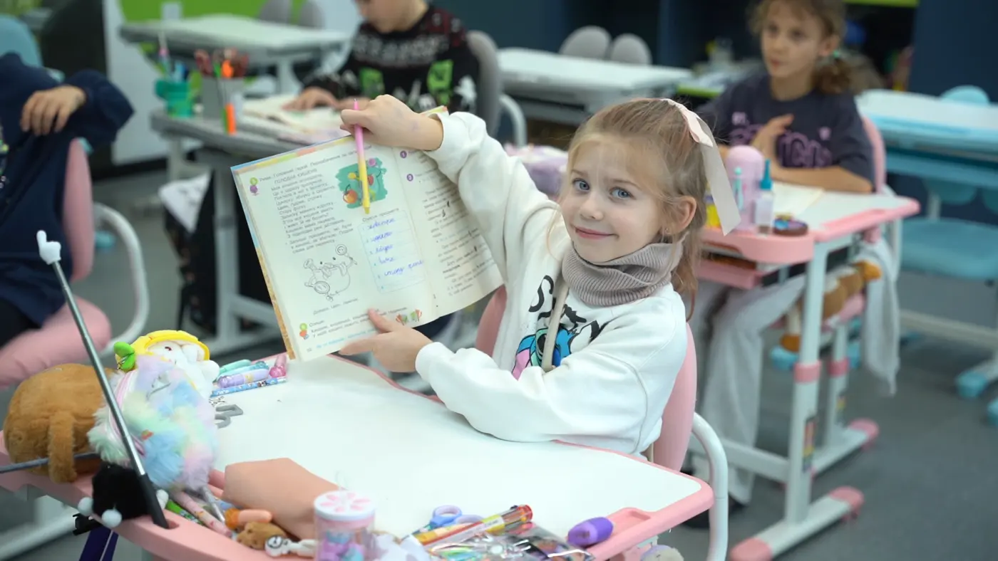 Учениця початкової школи з підручником